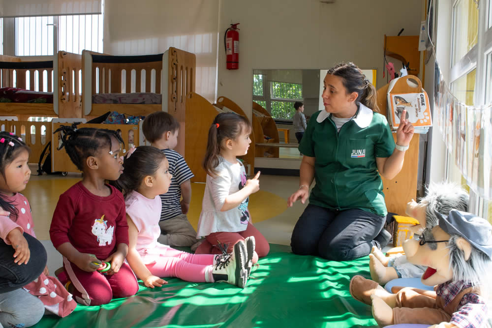 Educadora compartiendo una actividad con niñas y niños